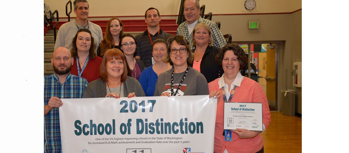 Members of the CCMS Staff with the banner recognizing them for being a school of distinction in 2017