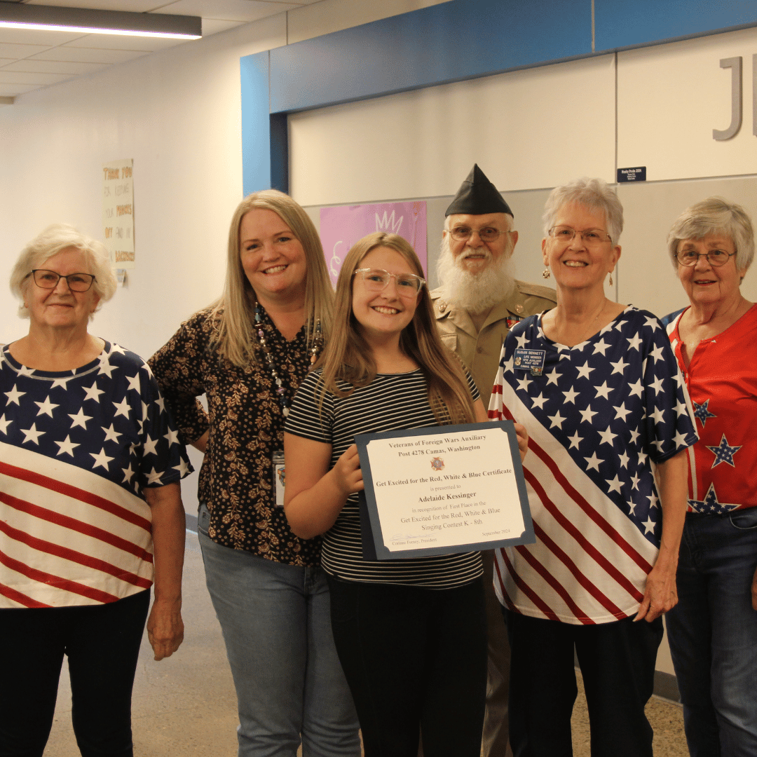 Student receiving award from VFW Auxiliary with parents watching