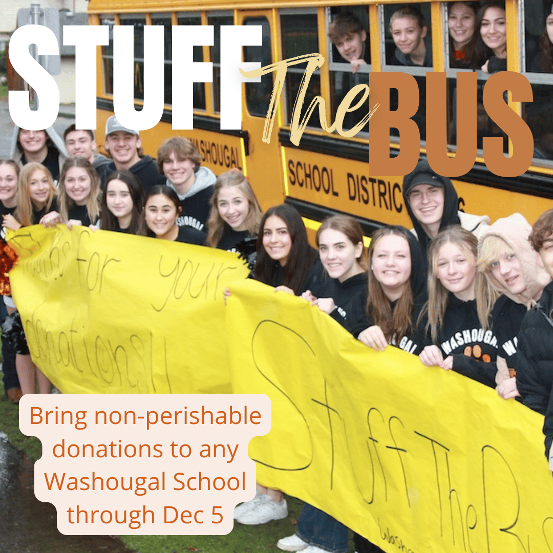 students in front of bus with banner for stuff the bus