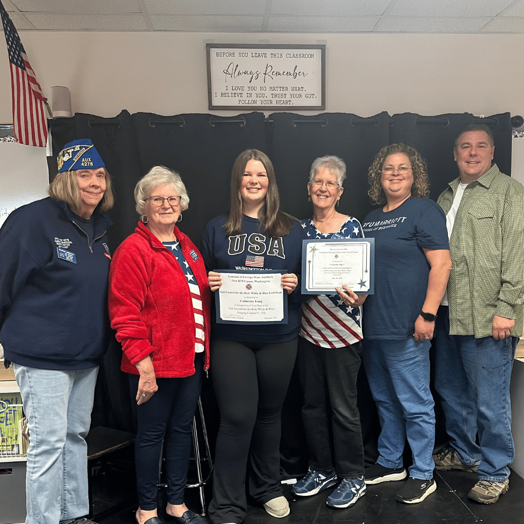 Student receiving award from VFW Auxiliary with parents watching