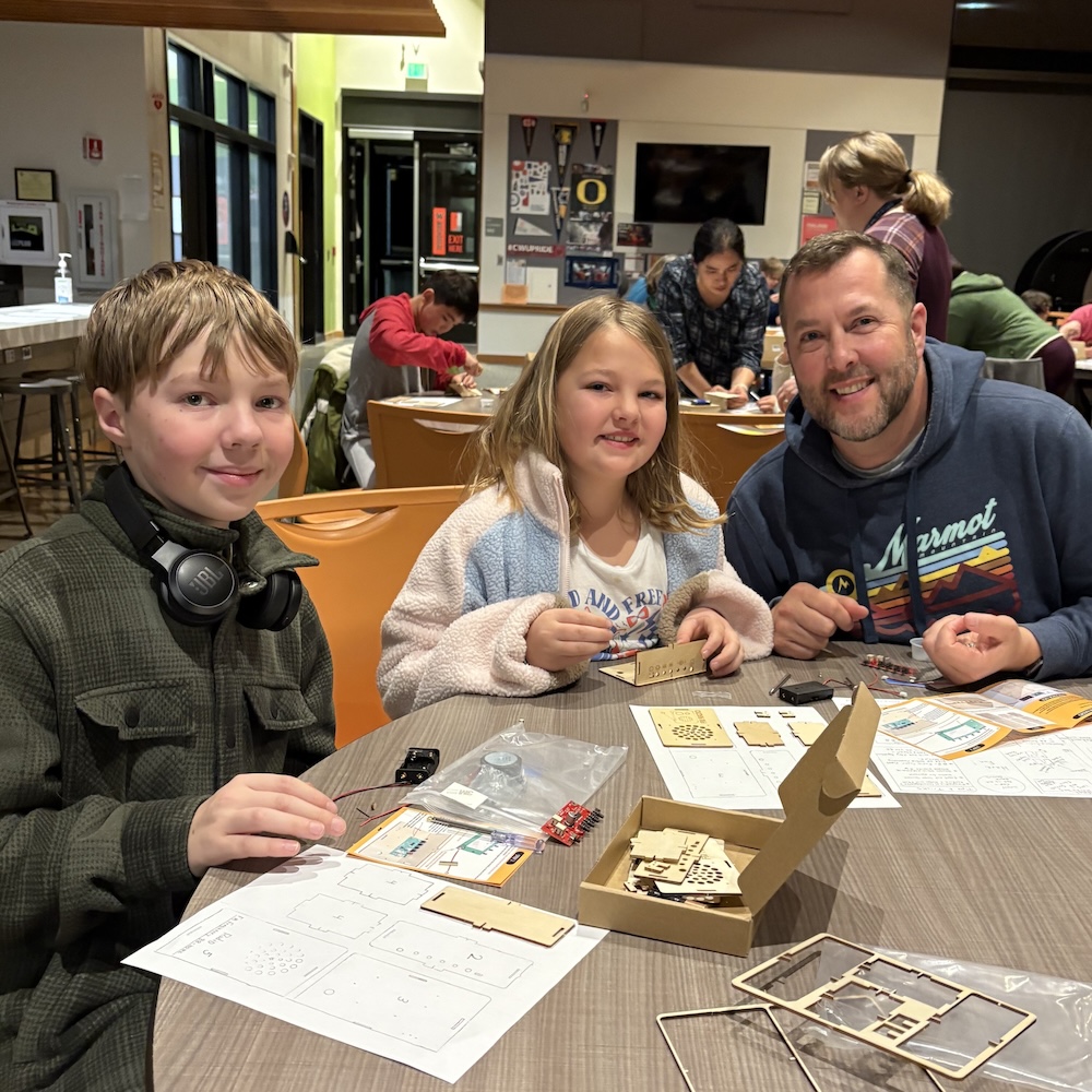 Students and parent at table with radio kit